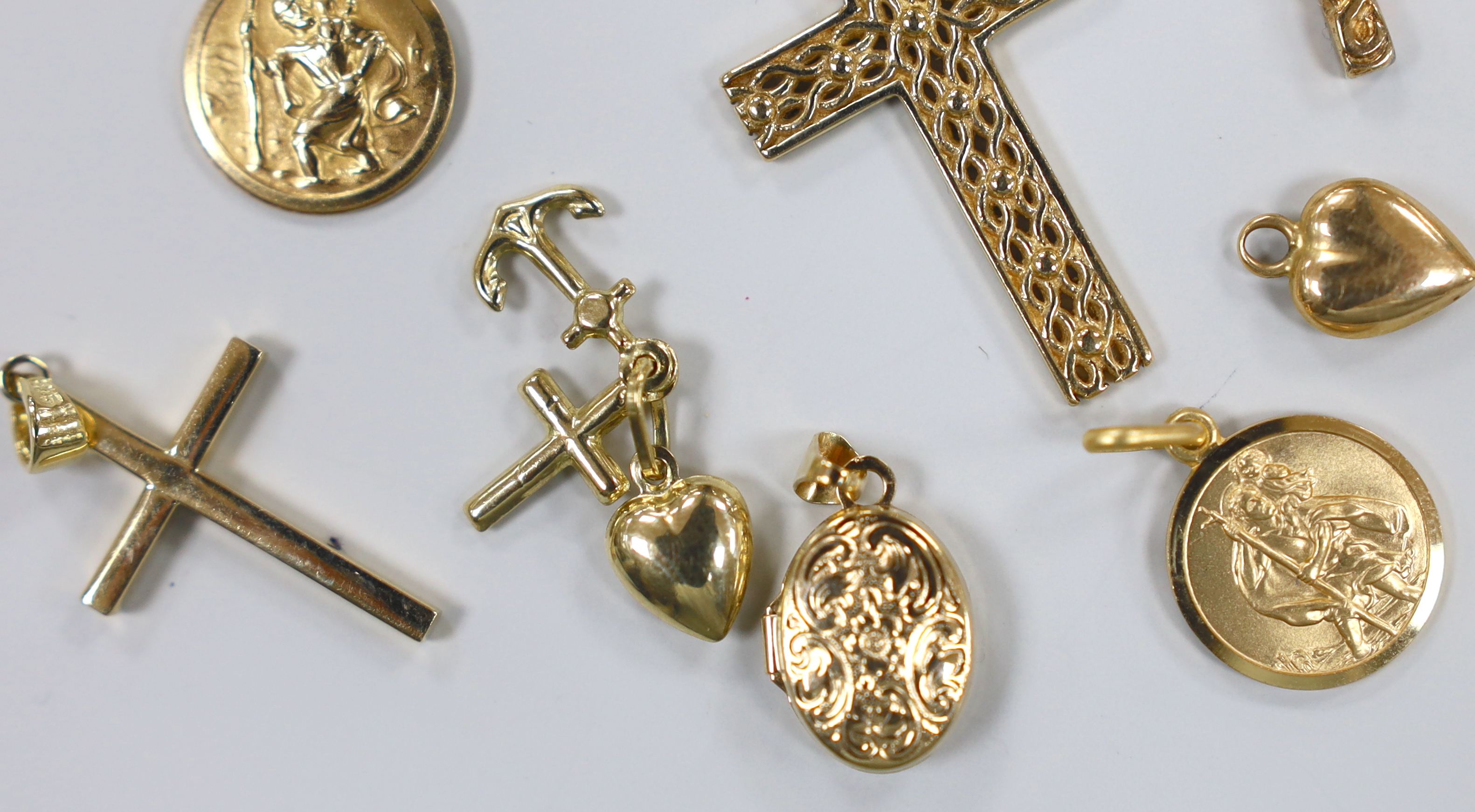 Three modern 9ct gold cross pendants, largest 34mm, a 9ct gold bean charm and St. Christopher pendant, a similar 375 pendant, cross pendant, locket and triple charm and two yellow metal items, gross weight 13.3 grams.